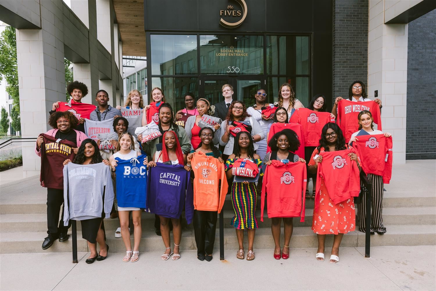 group of students standing with their college sweatshirts